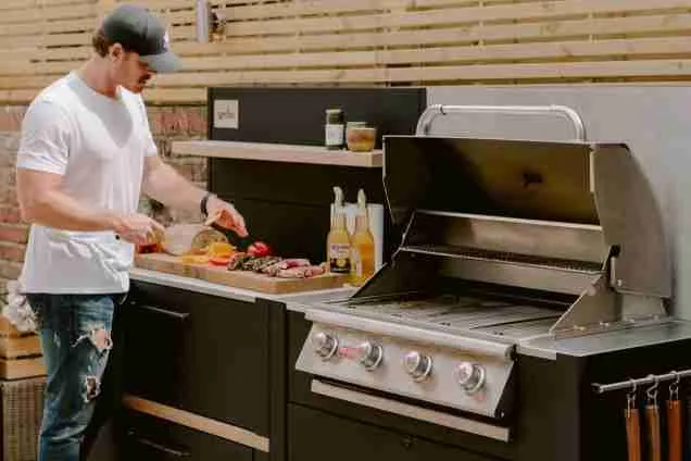 man cooking on grillo outdoor kitchen in chelsea london