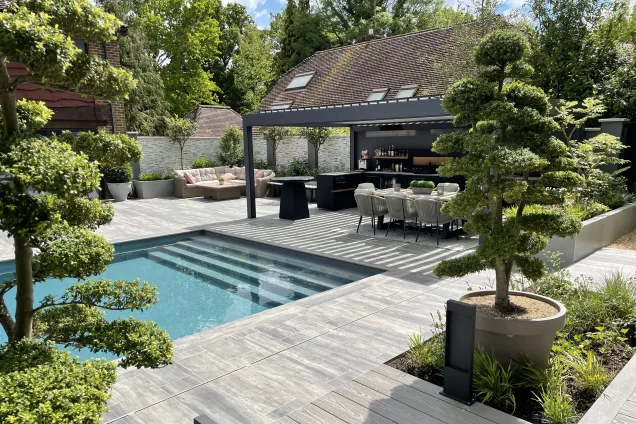 Outdoor kitchen in Copthorne West Sussex with outdoor seating next to a pool