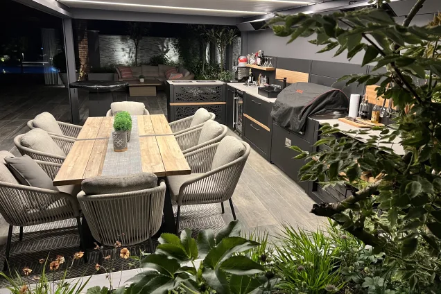 Outdoor kitchen in Copthorne West Sussex with outdoor seating at night
