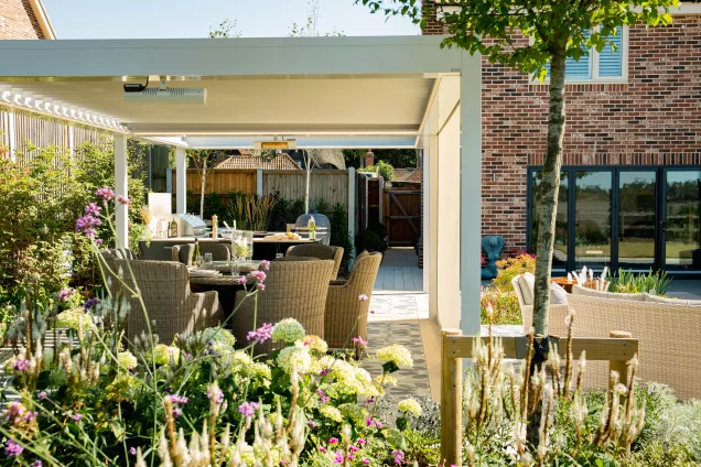 Grillo outdoor kitchen in ardleigh colchester under white pergola surrounded by shrubs