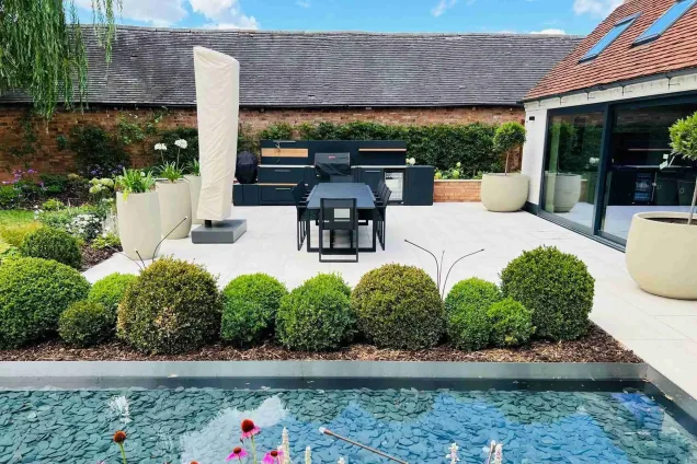 Outdoor kitchen in oldberrow henley-in-arden on patio with large dining table and water feature