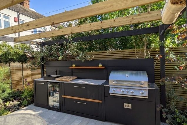 outdoor kitchen with bull gas grill station with drinks fridge and bin unit and storage cabinets