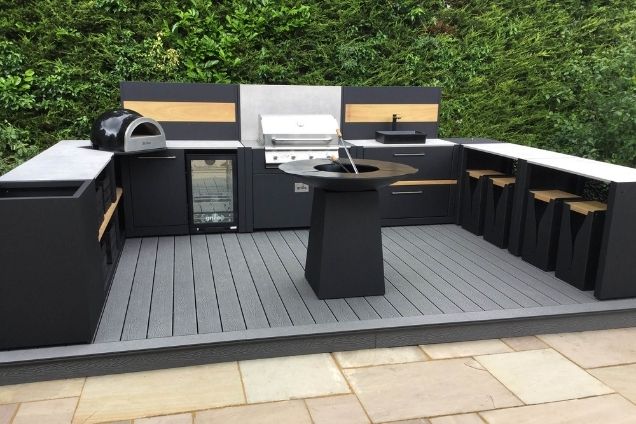outdoor kitchen with drinks fridge and bin, chefs anvil, bull gas grill and sink and seating