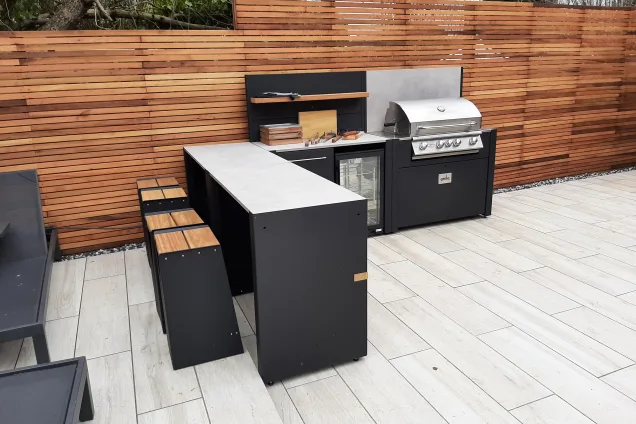 contemporary outdoor kitchen with cedar wood fencing and bar seating