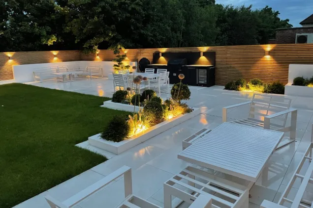 Outdoor kitchen in Bickley, Bromley on stone patio with lots of lights at night