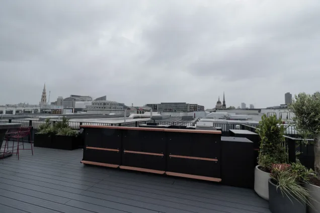 Outdoor kitchen in London with bar cabinets and stools