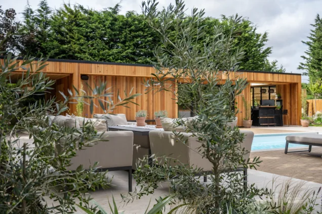 poolside seating overlooking outdoor kitchen under roof