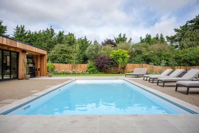 pool next to outdoor kitchen under summerhouse roof