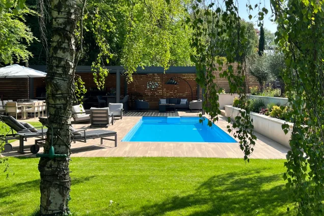 sunny garden view with pool, seating area and roofed outdoor kitchen in Stockport, Manchester