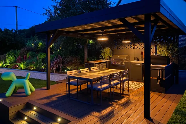 roofed outdoor kitchen on patio with seating area in Sherston, Malmesbury at night