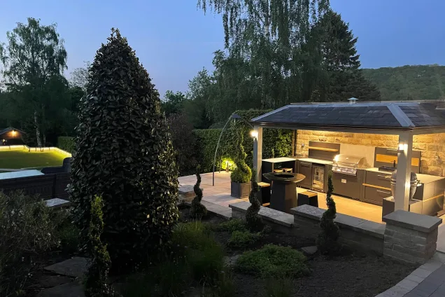 roofed outdoor kitchen at dusk with lights in Sheffield, garden view