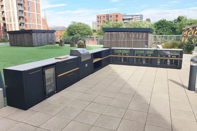 communal outdoor kitchen with Voltiq electric BBQ, built-in fridge and bar seating in Salford, Manchester