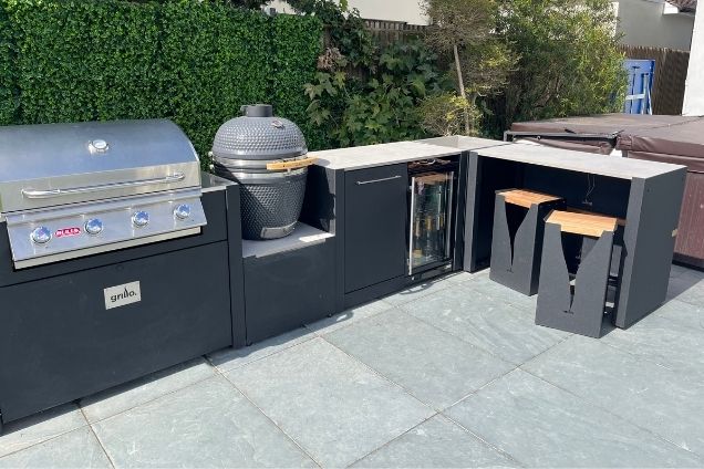 outdoor kitchen with BBQs and bar seating in Warlingham, Surrey
