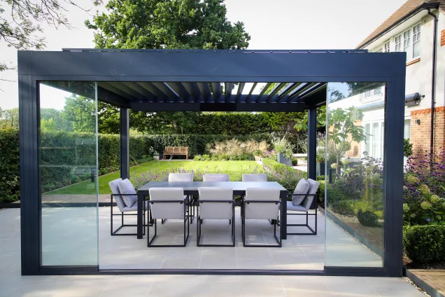 Seating area under pergola with sliding doors overlooking garden in Reigate