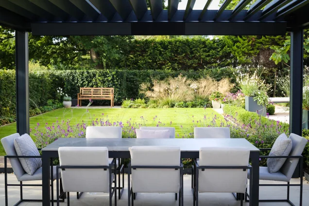 Seating area under pergola overlooking landscaped garden in Reigate