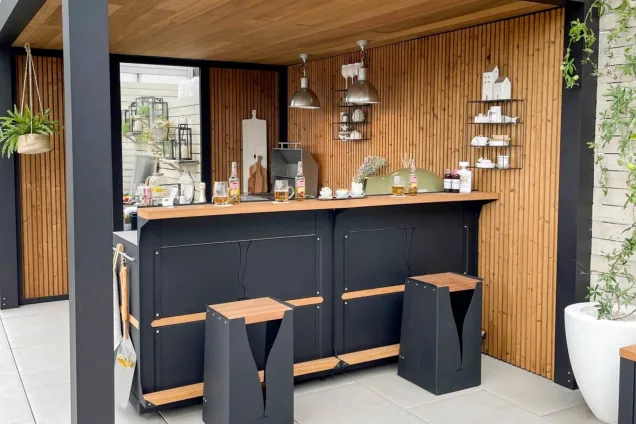 Outdoor kitchen in Chelsea flower show with bar table and stools