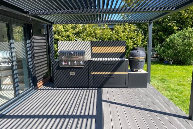 Outdoor kitchen in crowfield under pergola on decking in garden