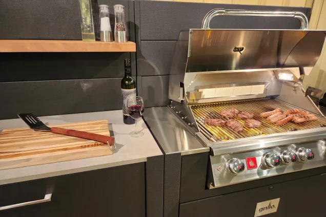 roasting sausages on Bull gas grill in outdoor kitchen in Oatlands, Sydney