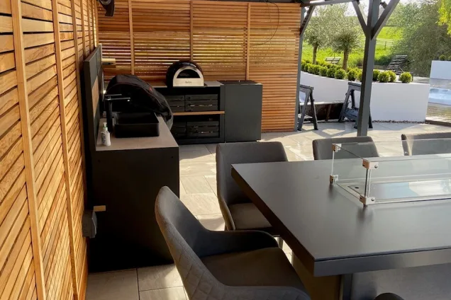 dining table overlooking outdoor kitchen under roof in Nuneaton, Warwickshire