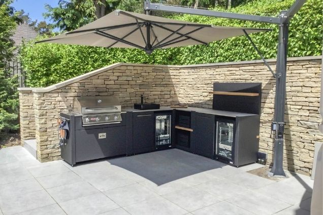 Outdoor kitchen in Dorset with bull bbq and sink under canopy on patio