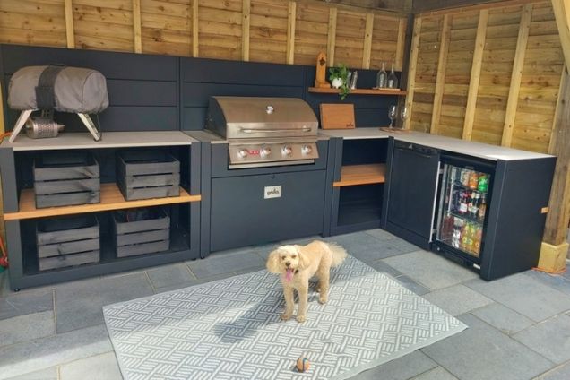 Outdoor kitchen in nottingham with bull bbq and dog on patio