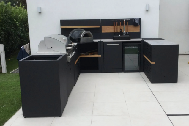 U-shaped outdoor kitchen on patio with Bull Gas Grill, wood-fired pizza oven, and built-in fridge in New Longton, Preston