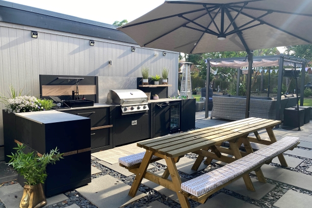L-shaped outdoor kitchen with seating area under parasol in Middleton, Milton Keynes