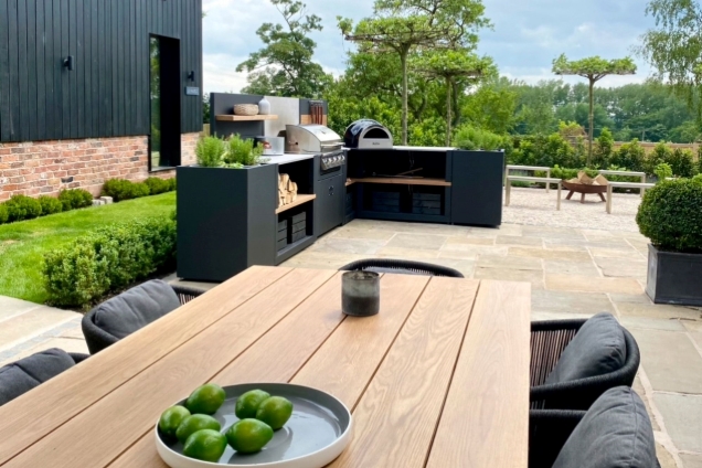 L-shaped outdoor kitchen on patio with dining area in Macclesfield, Cheshire