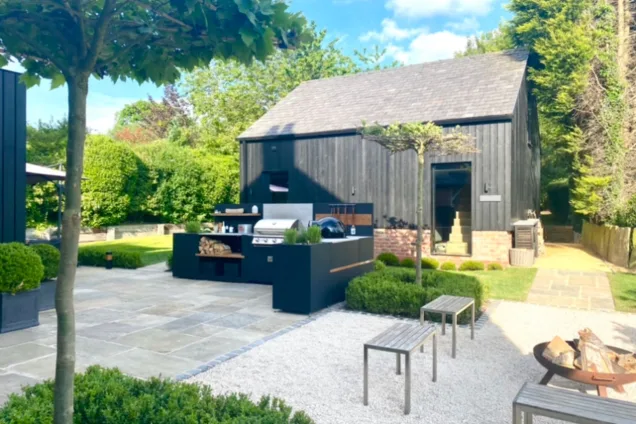 outdoor kitchen next to garden building in landscaped garden in Macclesfield, Cheshire