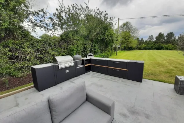 Outdoor kitchen in Sudbury with Charcoal, gas bbqs with storage units and seating on patio