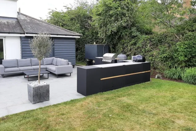 Outdoor kitchen in Sudbury with Charcoal, gas bbqs with storage units and drinks station and seating area
