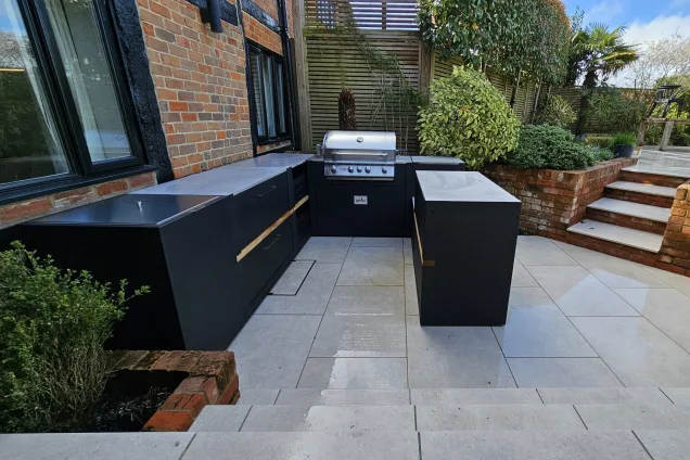 Outdoor kitchen in Berkshire with gas bbq and storage cabinet all on white patio