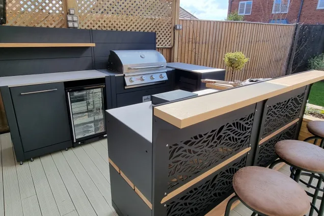 Outdoor kitchen in Kempston with stools at bar cabinets and gas bbq