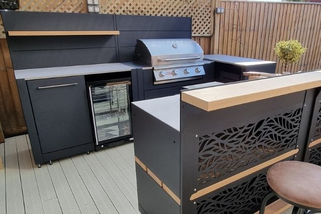 Outdoor kitchen in Kempston with stools at bar cabinets with habitat fascia