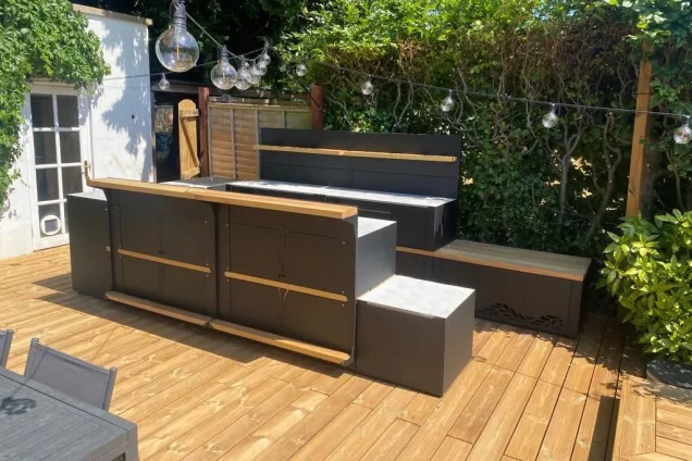 Outdoor kitchen in bristol on wooden decking with bar cabinets and benches