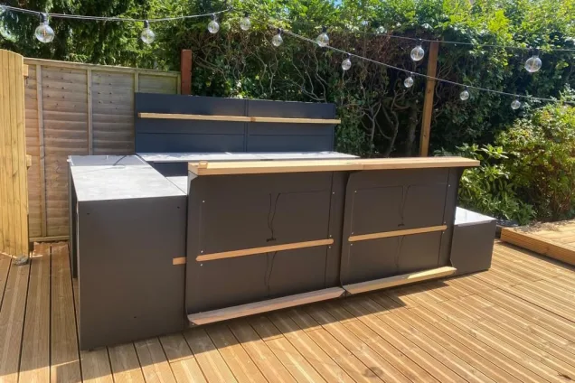 Outdoor kitchen in bristol on wooden decking with bar cabinets and benches and storage space