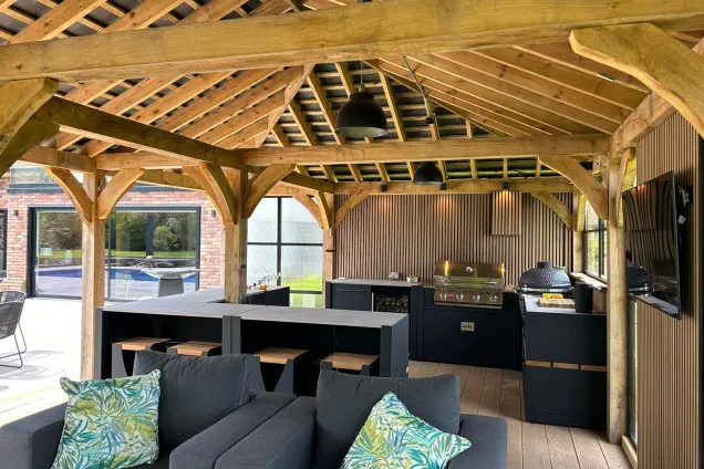 Outdoor kitchen in Hertfordshire with Bar table and stools with seating area