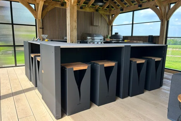 Outdoor kitchen in Hertfordshire with Bar table and stools under wooden cover