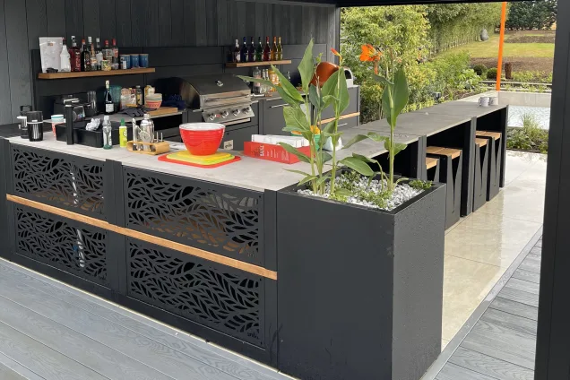 Outdoor kitchen in Bedfordshire flowers in planter and bull bbq and pizza oven