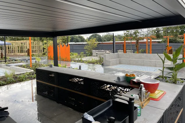 Outdoor kitchen in Bedfordshire flowers in planter and bull bbq and pizza oven under pergola