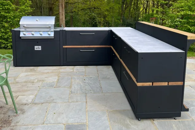 Outdoor kitchen in Cranleigh on patio in wooded garden with Bull gas bbq and storage units and bar cabinets