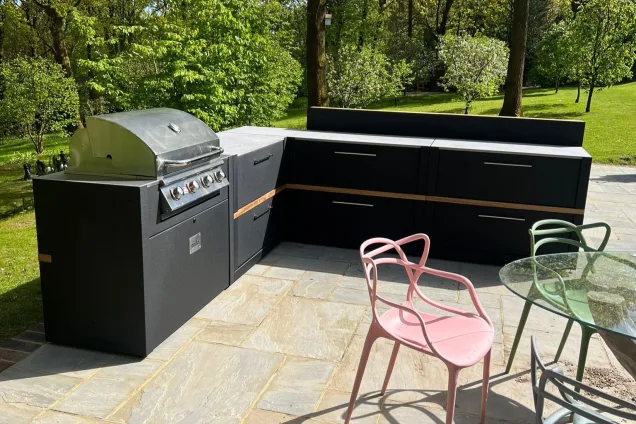 Outdoor kitchen in Cranleigh on patio in wooded garden with Bull gas bbq and bar cabinets