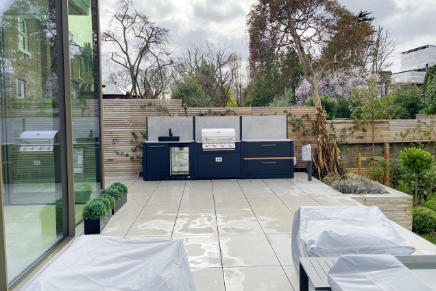 Outdoor kitchen in ealing on white patio with Bull bbq and sink and fridge