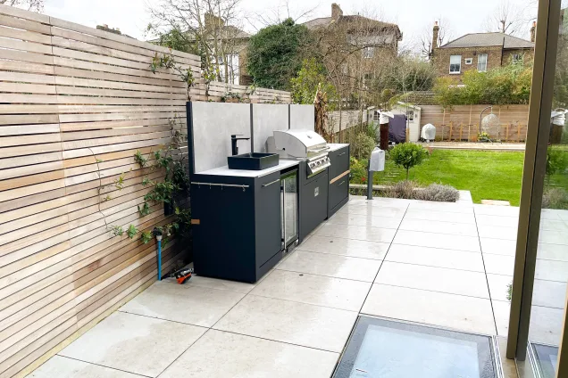 Outdoor kitchen in ealing on white patio with Bull bbq