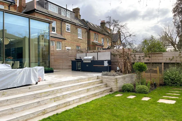 Outdoor kitchen in ealing on patio next to grass garden