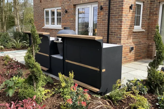 Outdoor kitchen in surrey with Gusto bbq, storage and bar stools on patio with flowers