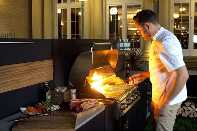 person cooking on bull gas grill station in grillo kitchen