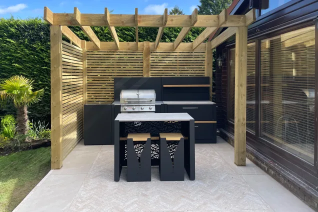 outdoor kitchen with bar seating and gas BBQ under pergola in Edlesborough, Dunstable