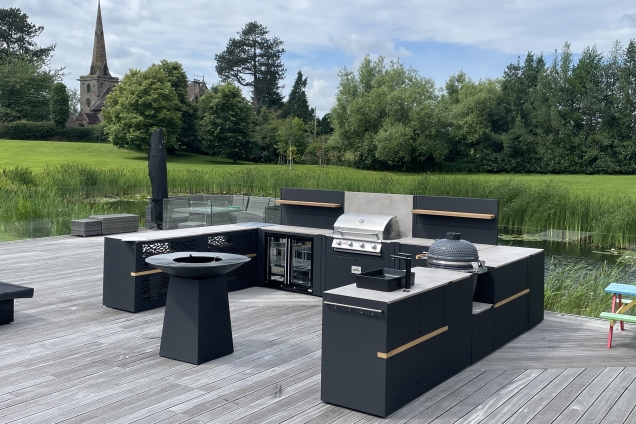 Outdoor kitchen in Stafford with chefs anvil and bar table and stools cabinets and bull gas bbq