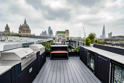 outdoor kitchen on london roof terrace with two voltiq bbqs, standing bars and storage